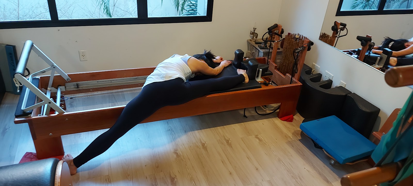 Aluna em alongamento profundo sobre o reformer